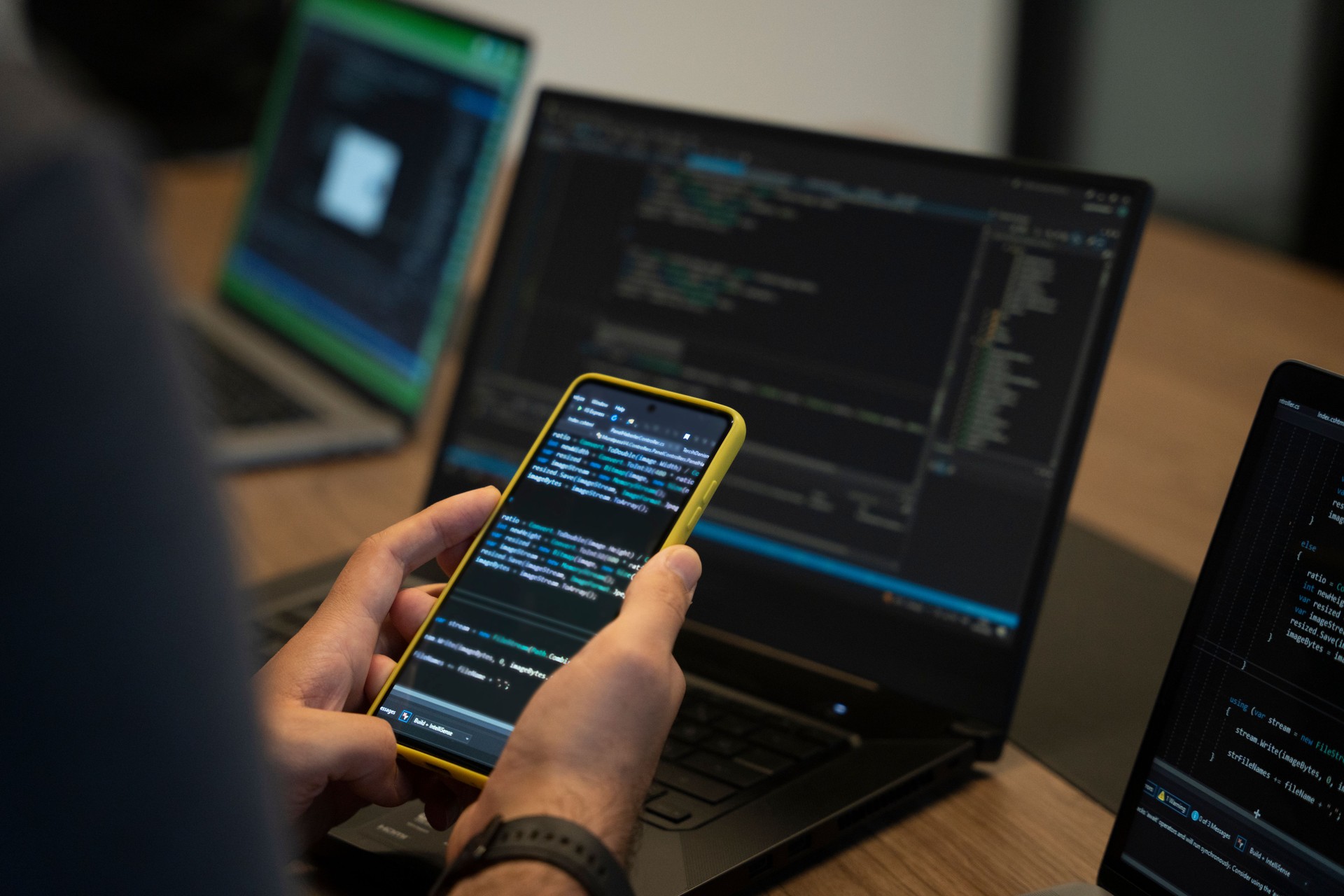 A programmer who develops software for mobile devices checks the software he has developed on the phone.